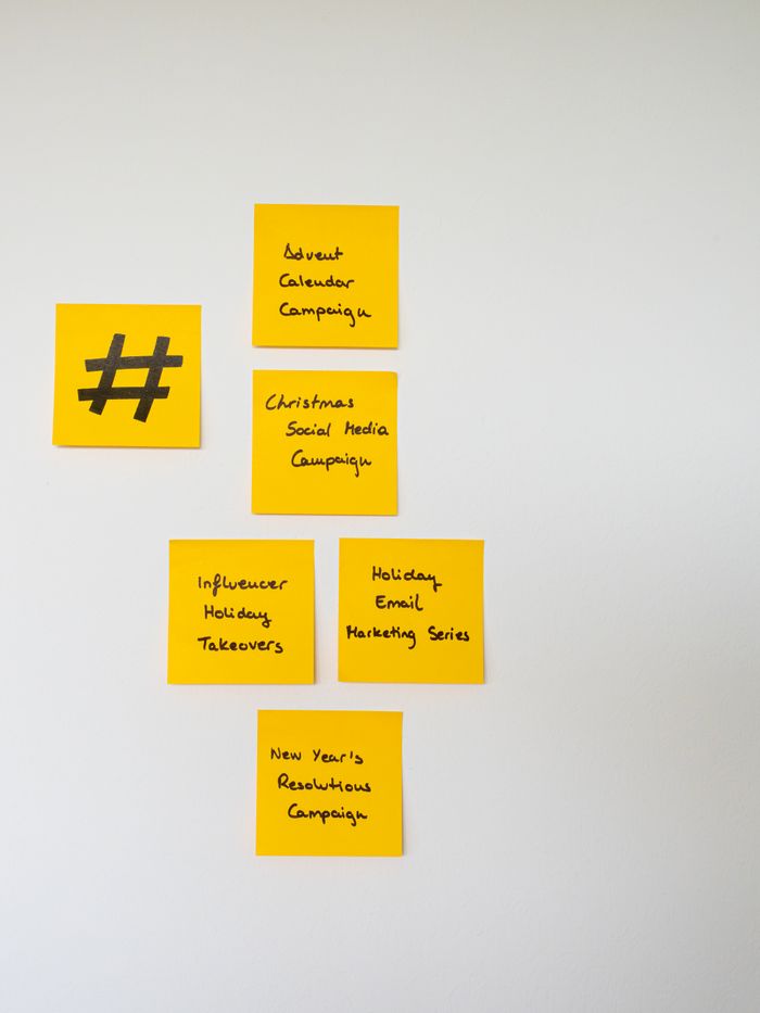 about-us-01 Yellow sticky notes with handwritten marketing campaign ideas on a wall.